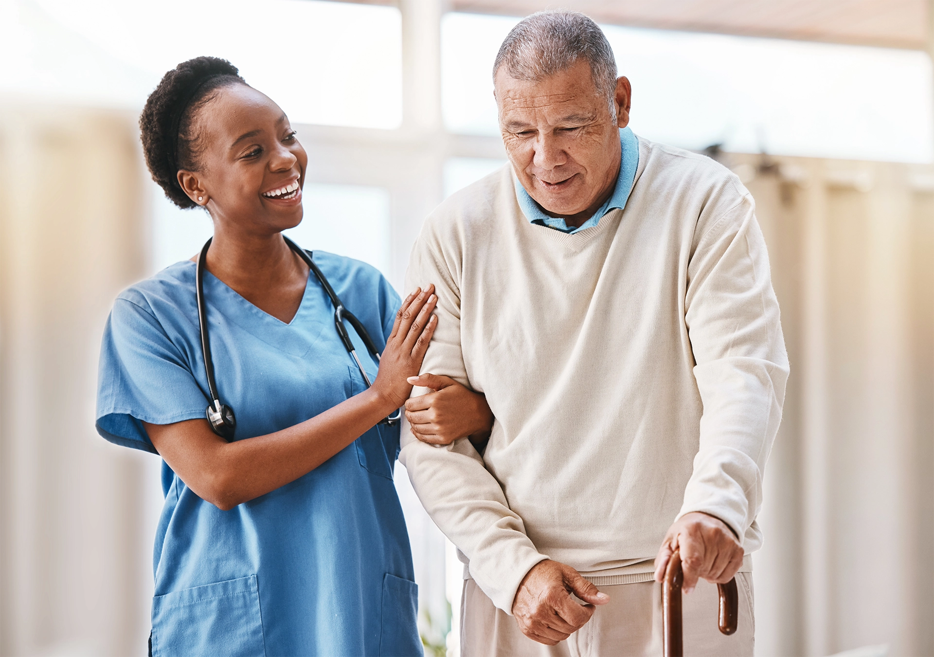 Compassionate hospice caregiver assisting an older adult with mobility