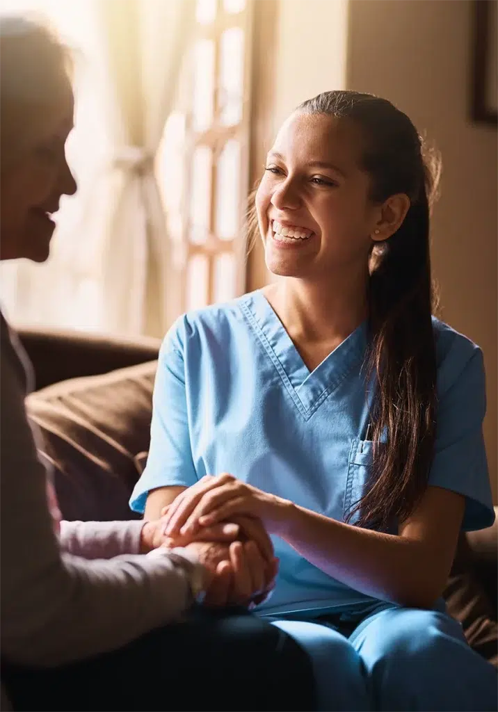 Hospice nurse holding a patient's hand while providing compassionate care and emotional support at home.