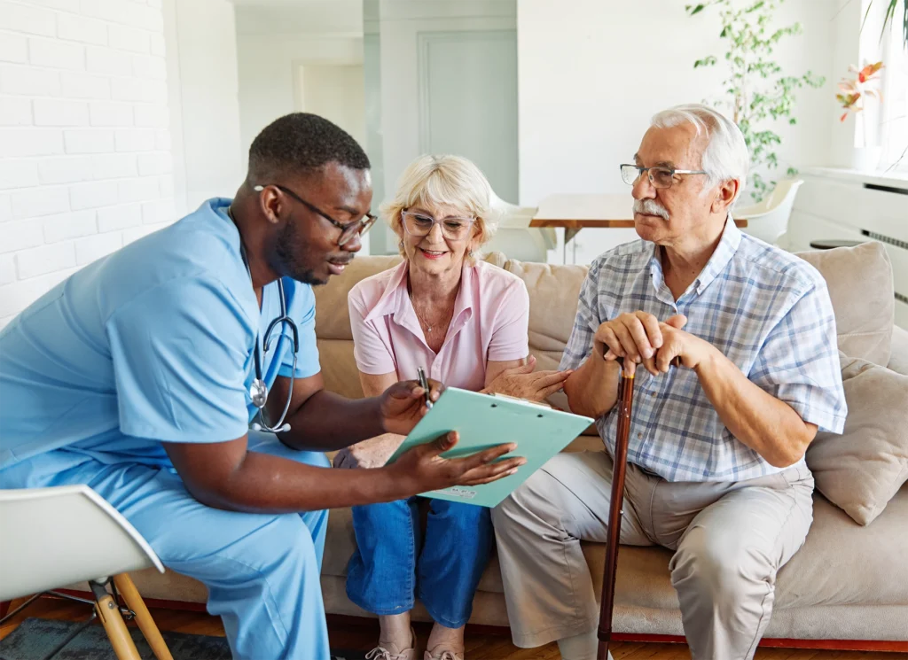 Hospice care professional discussing hospice eligibility and care options with an older couple during an in-home family consultation.